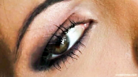 Seductive close-up of horny brunette's hazel eye with smokey makeup in solo dildo scene
