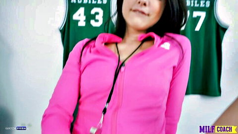 Sexy Asian MILF coach in pink zip-up jacket smiling with cleavage in locker room