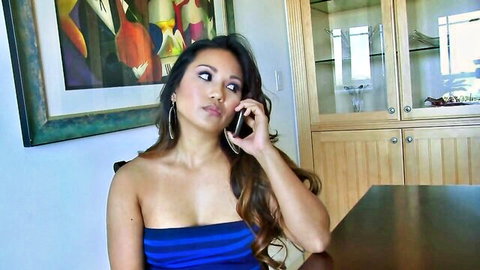 Coquettish Asian babe with dark hair on phone, blue tube top