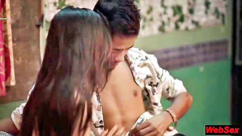 Indian teen couple in passionate embrace, woman kissing man's bare chest