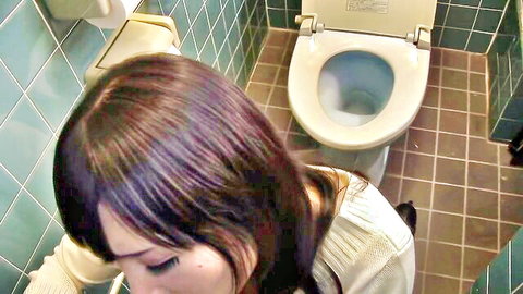 Brunette woman with intense expression sitting on toilet in passionate bathroom scene