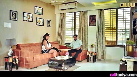 Curvy Indian MILF in tight shorts and cleavage top sitting legs crossed with man on sofa