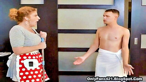 Redhead mature maid in apron shocked by shirtless hunk in towel in hotel room