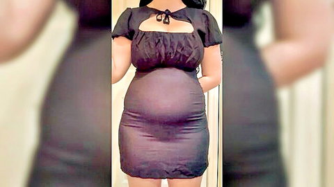 Curvy pregnant woman in black dress showing off big belly