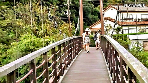 Japanese MILF in white dress walking on outdoor bridge with friend