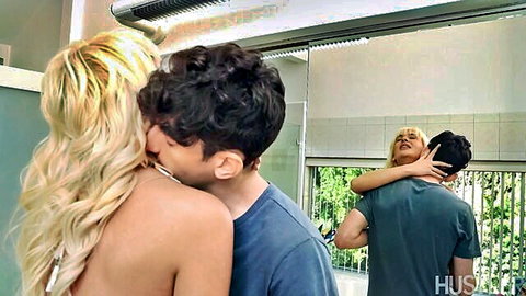 Blonde babe in MMF threesome, kissing one guy while another embraces from behind
