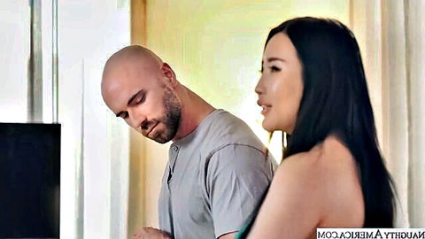 Bald man intimately embraces stunning Asian woman in green top