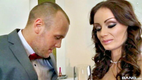 Abbie Cat in elegant dress with suited man, intimate close-up