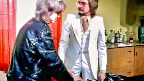 Vintage 1970s couple in leather jacket and white suit, intimate chat from Up In Flames classic porn