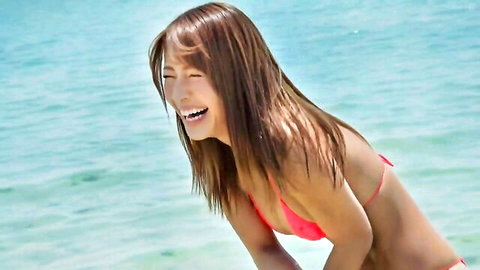 Young Japanese beauty laughing in tight pink bikini on beach teasing perky medium tits