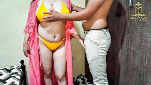 Sara Yassin in yellow bikini, man fondling her from behind