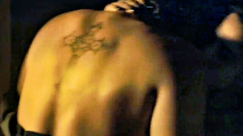Muscular tattooed man's bare back viewed from behind with manicured hand gripping shoulder