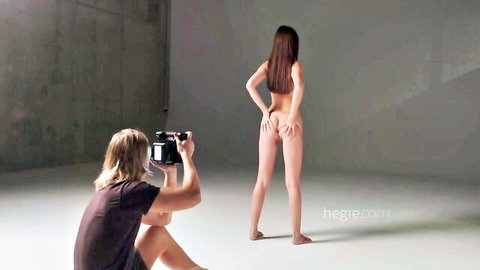 Nude brunette model spreads her bare ass cheeks for female photographer in sensual studio shoot
