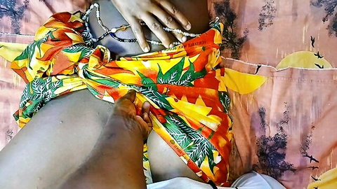 Youthful ebony teen in colorful wrap skirt, legs spread exposing intimate area
