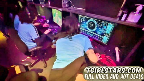 Trans gamer girls in tight blue shirts and shorts intensely gaming on neon-lit PCs