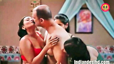 Busty Indian babe in red lingerie passionately kissing bald man's lips with hand on his bare chest
