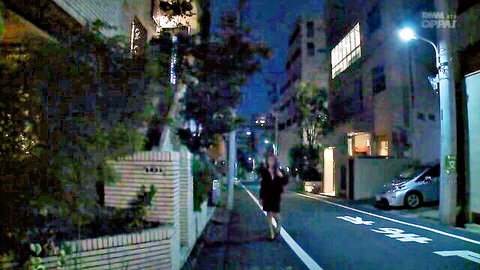 Petite Japanese babe in short skirt walking naughty on dark urban street at night