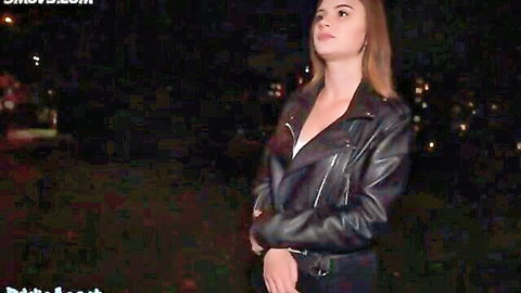 Sexy brunette babe in leather jacket showing deep cleavage outdoors at night