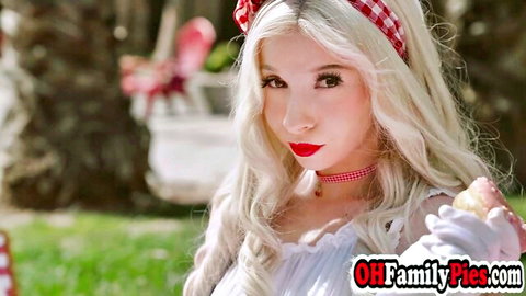 Blonde teen in frilly lingerie holds pink popsicle to red lips seductively outdoors