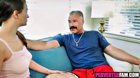 Young stepdaughter in pink top touches stepdad's leg on couch for Father's Day gift