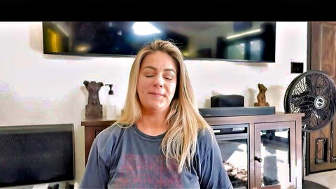 Blonde MILF smiling eyes closed in loose Slayer t-shirt teasing in living room