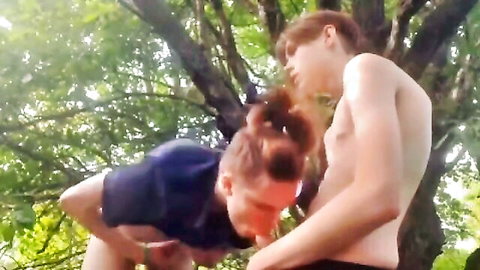 Redhead twink kneels sucking muscular twink's cock outdoors in woods gay blowjob