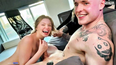 Skinny blonde teen with small natural tits nude laughing on tattooed guy's lap with big cock visible