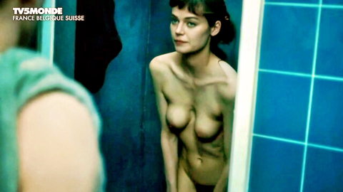 Nude brunette with perky tits stands sideways in blue-tiled bathroom mirror reflection