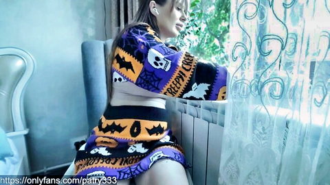 Patry333 in sexy Halloween sweater, teasing side pose with bats and skulls