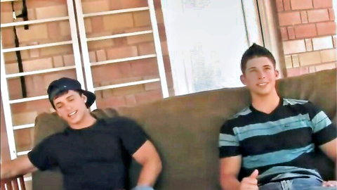 Two athletic frat boys lounging casually on couch, smiling