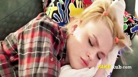 Blonde woman in pigtails sleeping peacefully in plaid shirt under blanket