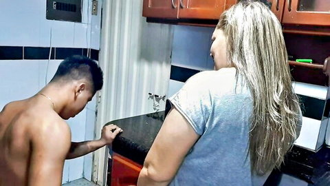 Blonde mature stepmom in gray top bent over counter with shirtless Asian guy