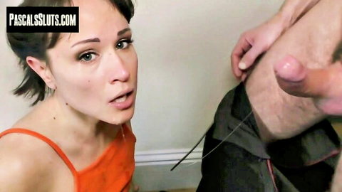 Brunette babe kneels with open mouth staring at thick hard cock gripped by man's hand for blowjob