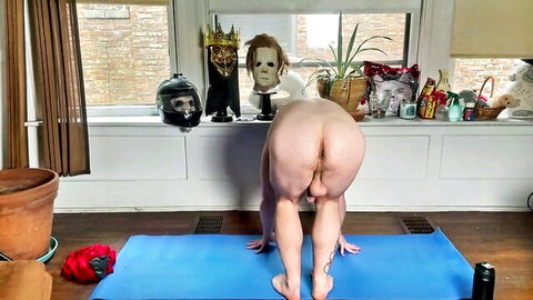 Muscular naked young guy in downward dog yoga pose exposing bare ass and balls