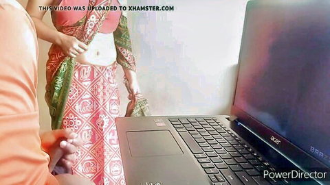 Indian maid in pink saree exposing midriff in front of laptop