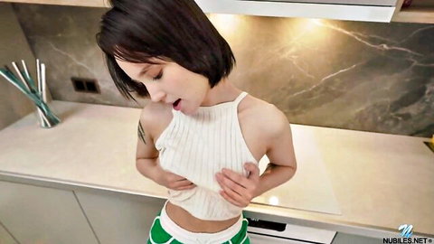 Young Asian babe squeezing perky tits through wet white tank top in kitchen, mouth open wide