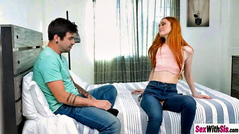 Redhead stepsister in pink crop top chats with tattooed stepbrother on bed