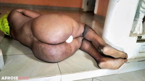 Chubby ebony babe lies naked on floor with white tail butt plug inserted in her fat asshole