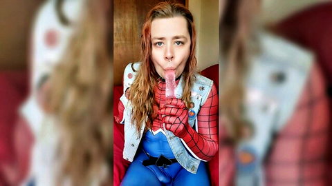 Trans Spider-Man cosplayer with wet red hair sucking pink dildo, drooling