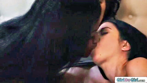 Passionate lesbian kiss between two dark-haired women fooling around next to BFF