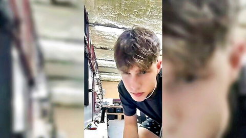 Handsome young twink in floral swim trunks leans forward in RV for gay solo tease