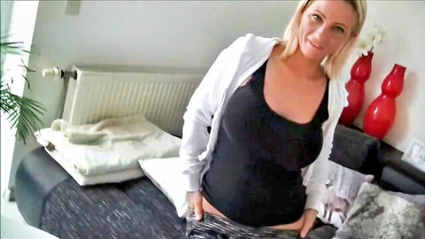 Blonde woman smiling seductively in open hoodie and leggings, teasing pose