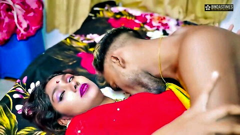 Muscular Indian man passionately kisses curvy housewife's neck and gropes her big tits over red saree on bed