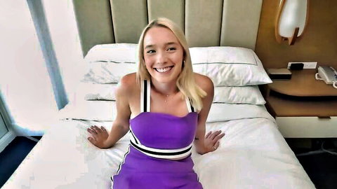 Petite blonde teen with green eyes and freckles smiling in purple dress