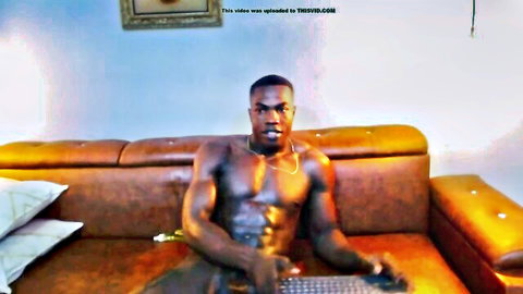 Muscular ebony stud shirtless flexing ripped abs gold chain on couch webcam solo
