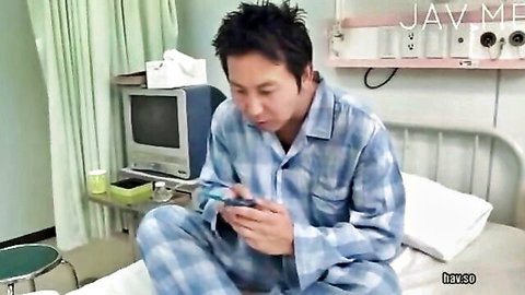 Asian man in hospital pajamas sitting in bed checking phone