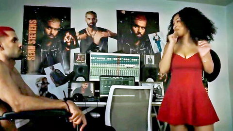 Curvy ebony babe with big tits in tight red dress teases shirtless muscular redhead guy in music studio