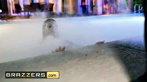 Sexy wet blonde smiling in foggy pool at wild neon-lit night party