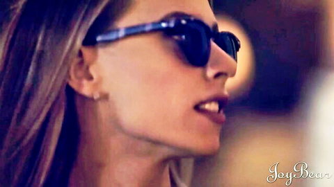 Brunette beauty in dark sunglasses with parted glossy lips in seductive profile view