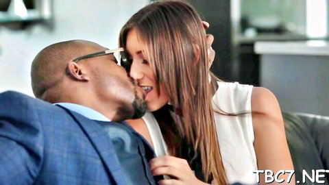 Black man in blue suit kissing pretty Asian teen with long brown hair in white top